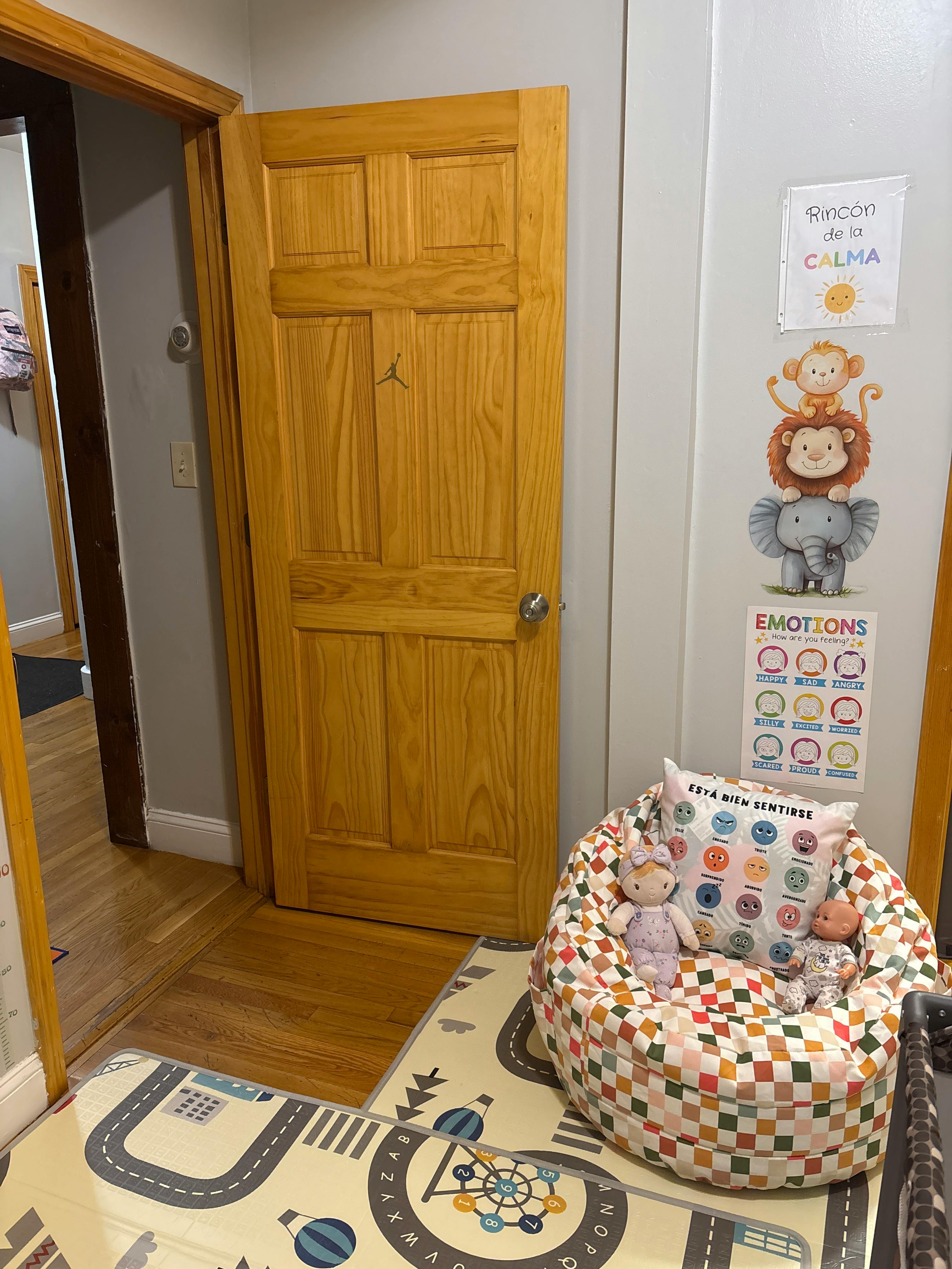 A child's calm-down corner with emotion posters and a plush seating area