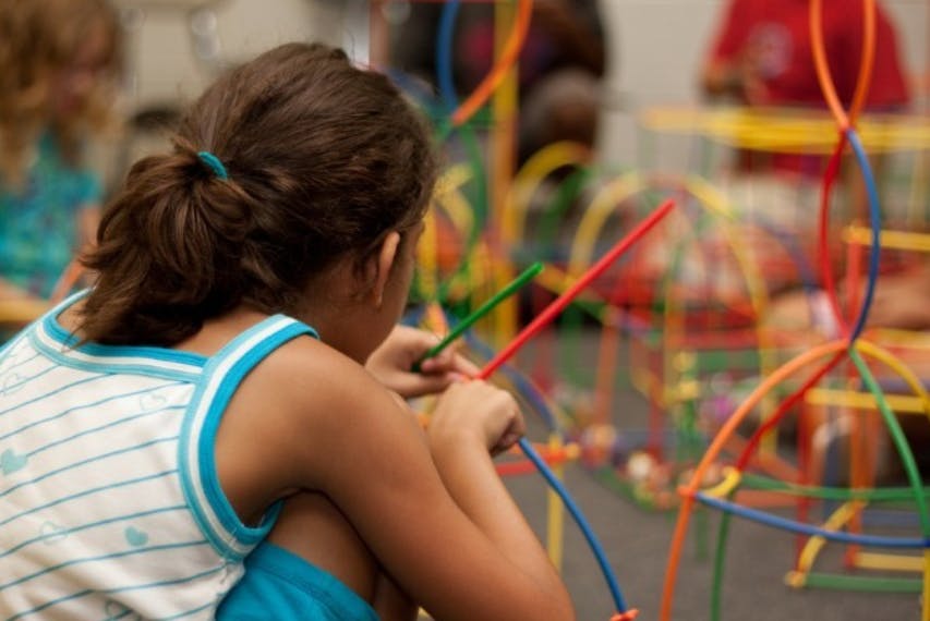 Child playing with colorful construction toy pieces