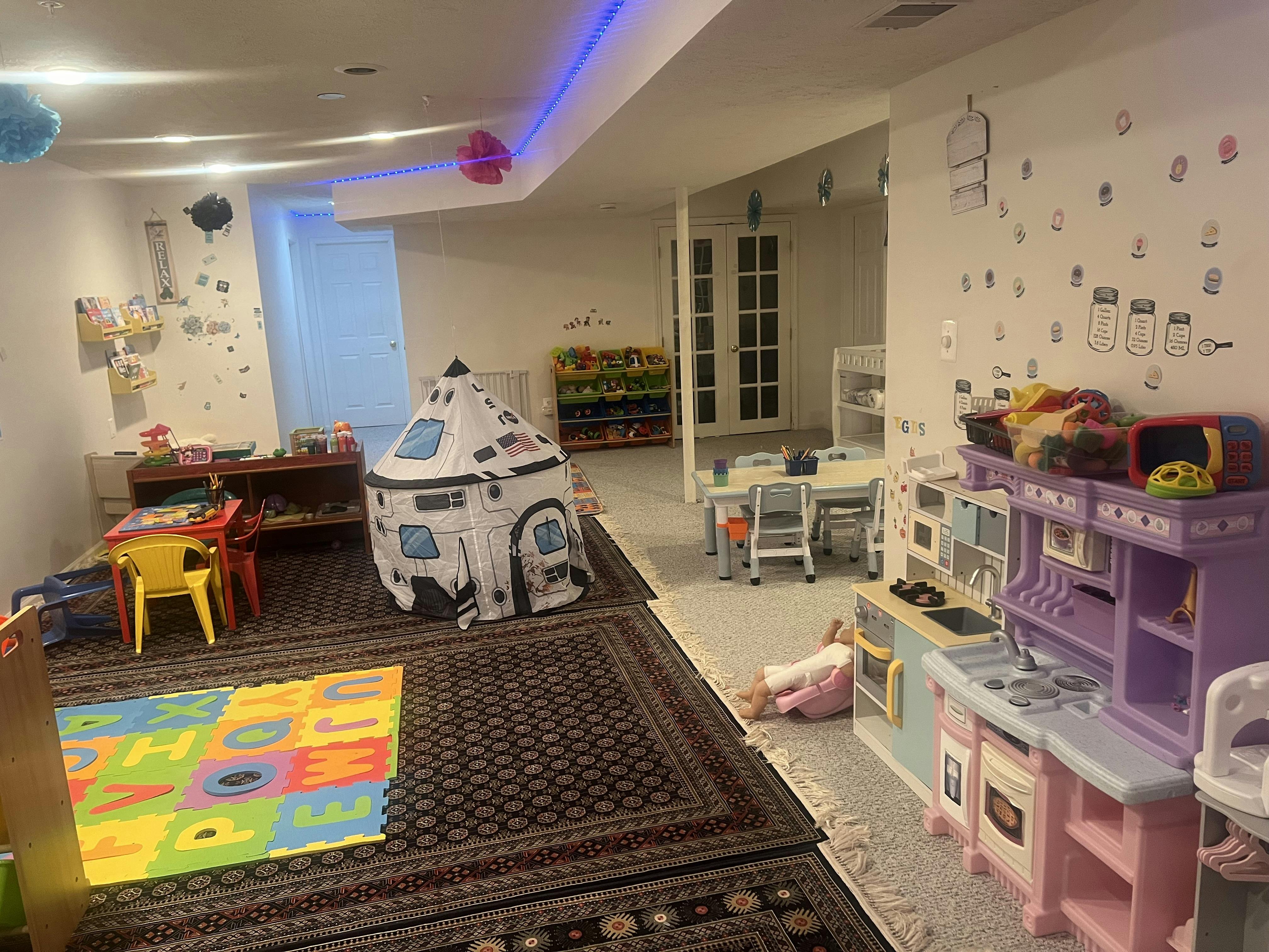 Child playing in a room with a toy kitchen and a play tent