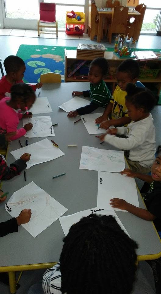 Children drawing at a table in a classroom