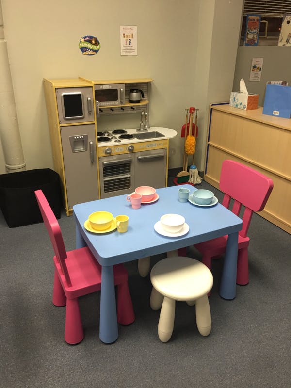 Play kitchen set with a blue table and pink chairs