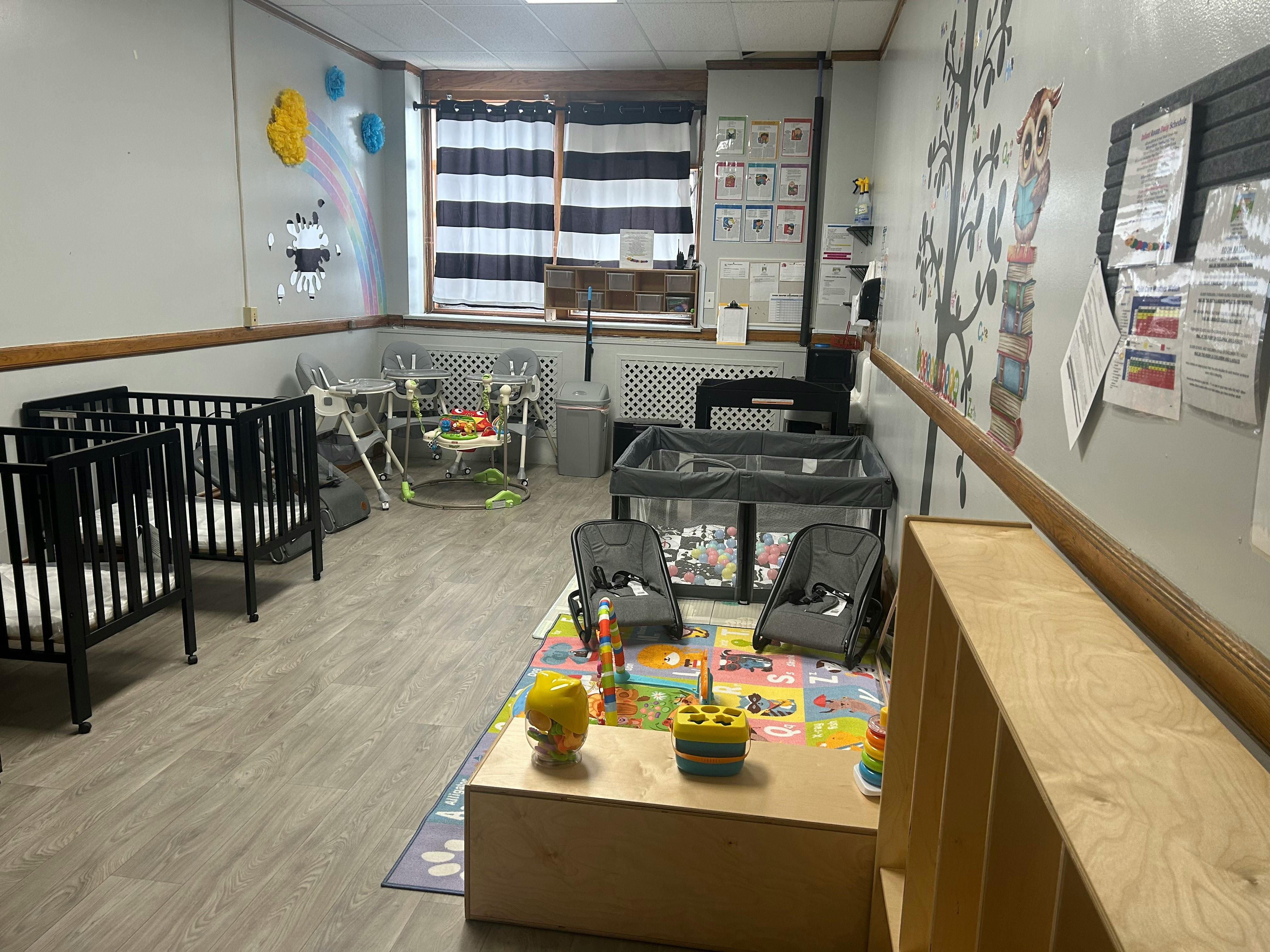 Baby room with cribs, playards, high chairs, and activity rugs
