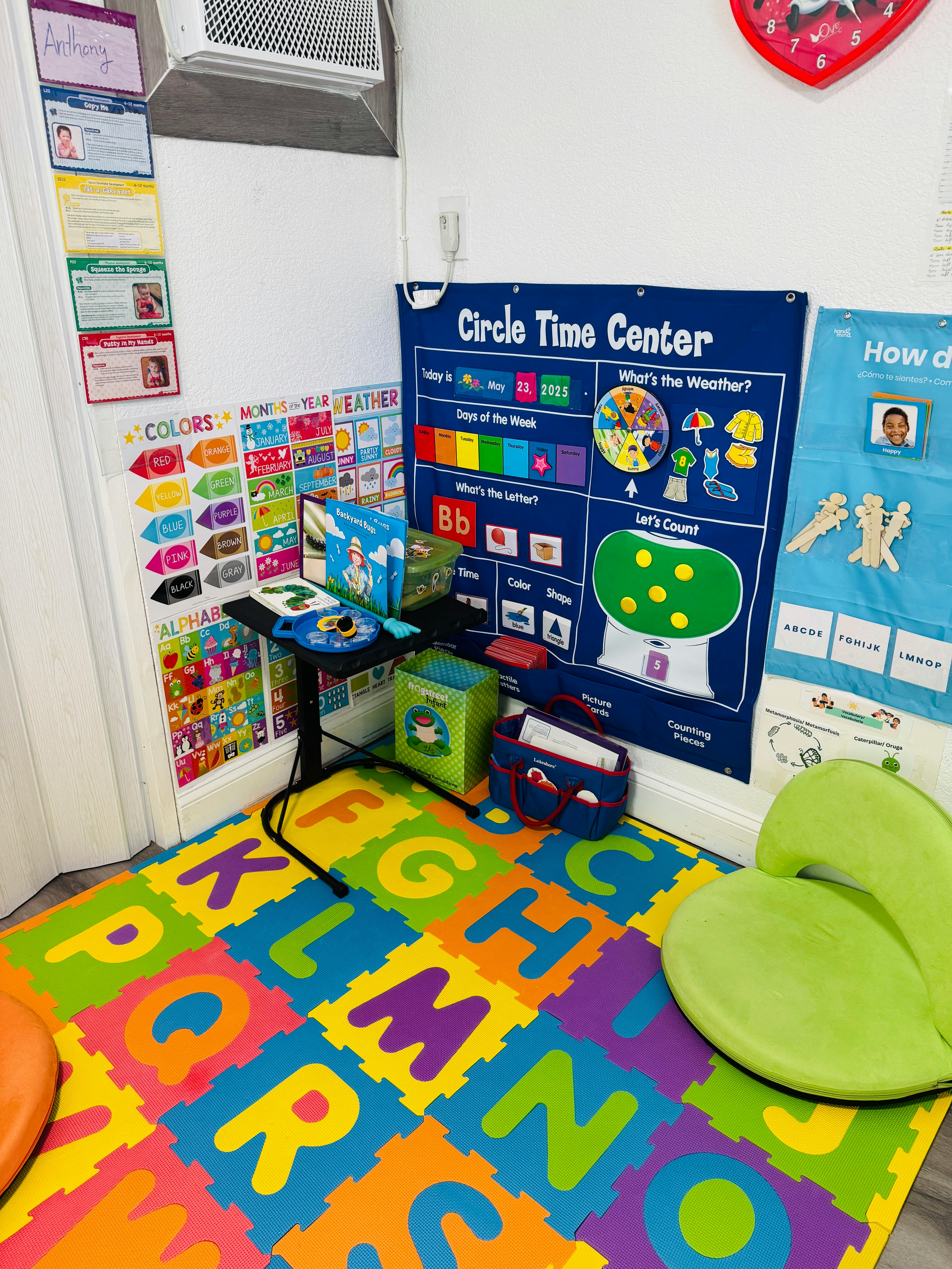 Classroom corner with alphabet floor mat, charts, and green chair