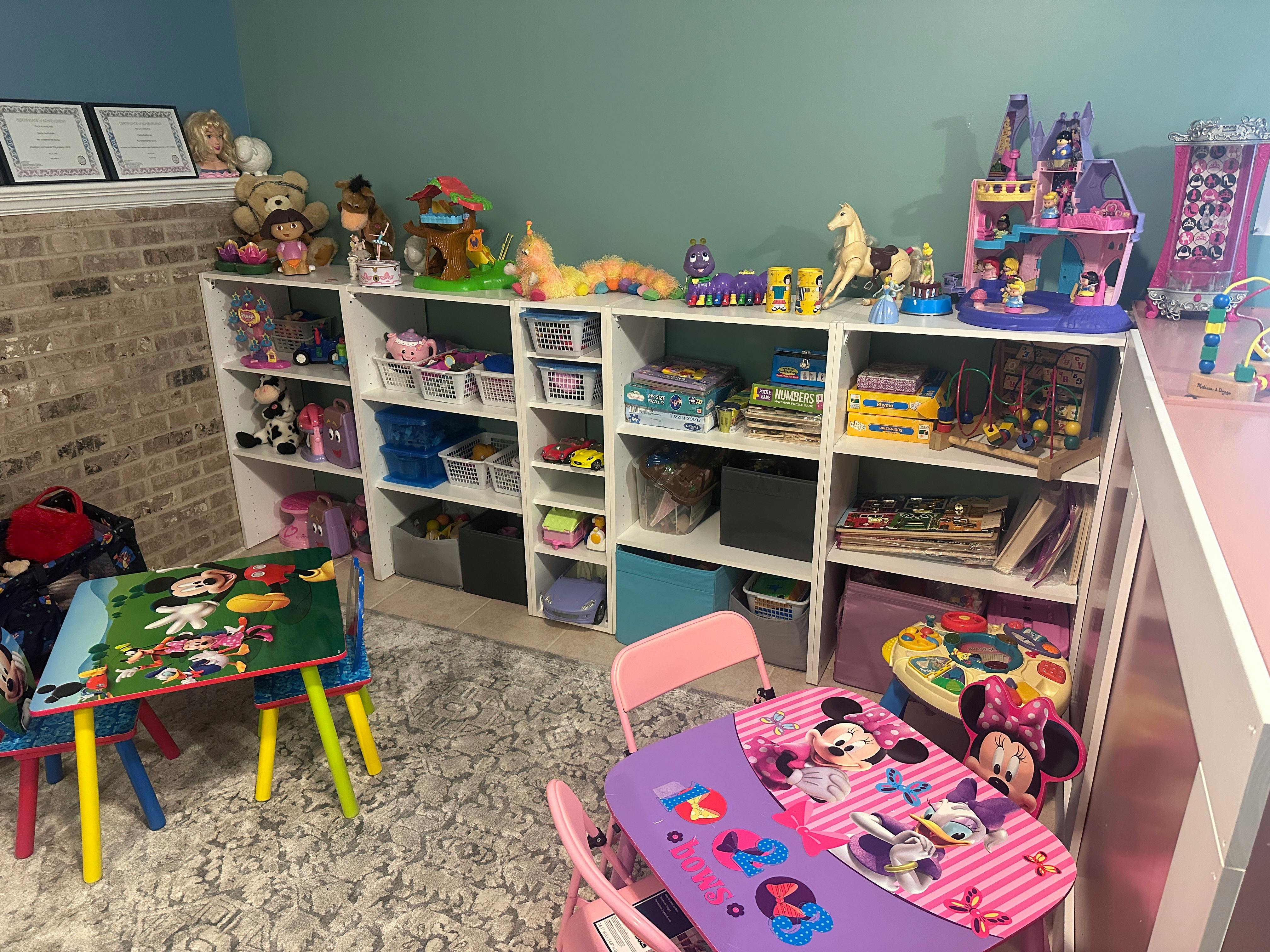 Playroom with shelves of toys and two small tables with chairs