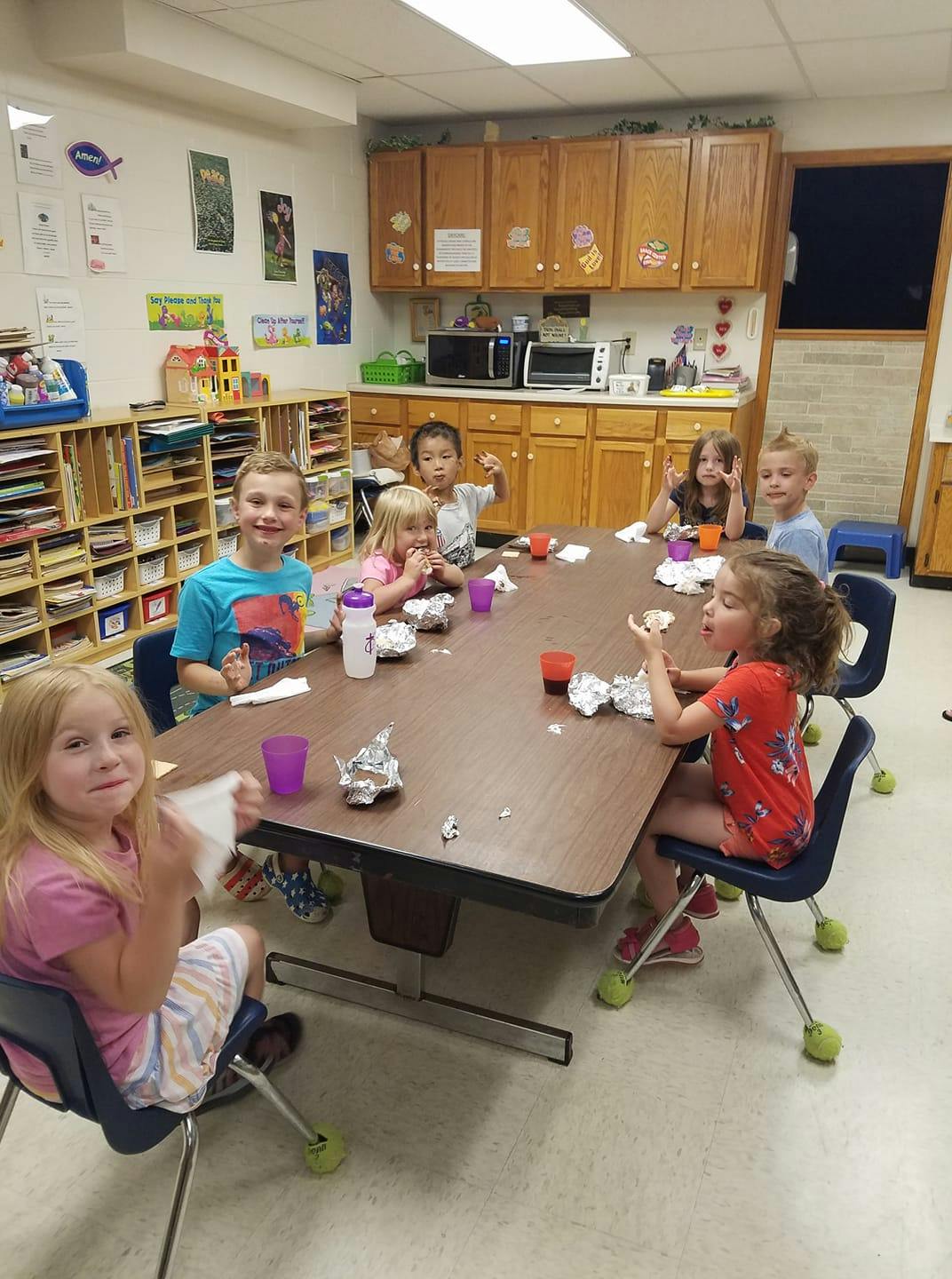 Children sitting at a table in a classroom