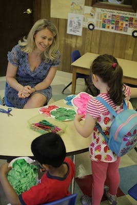 Adult and two children at a table with craft supplies