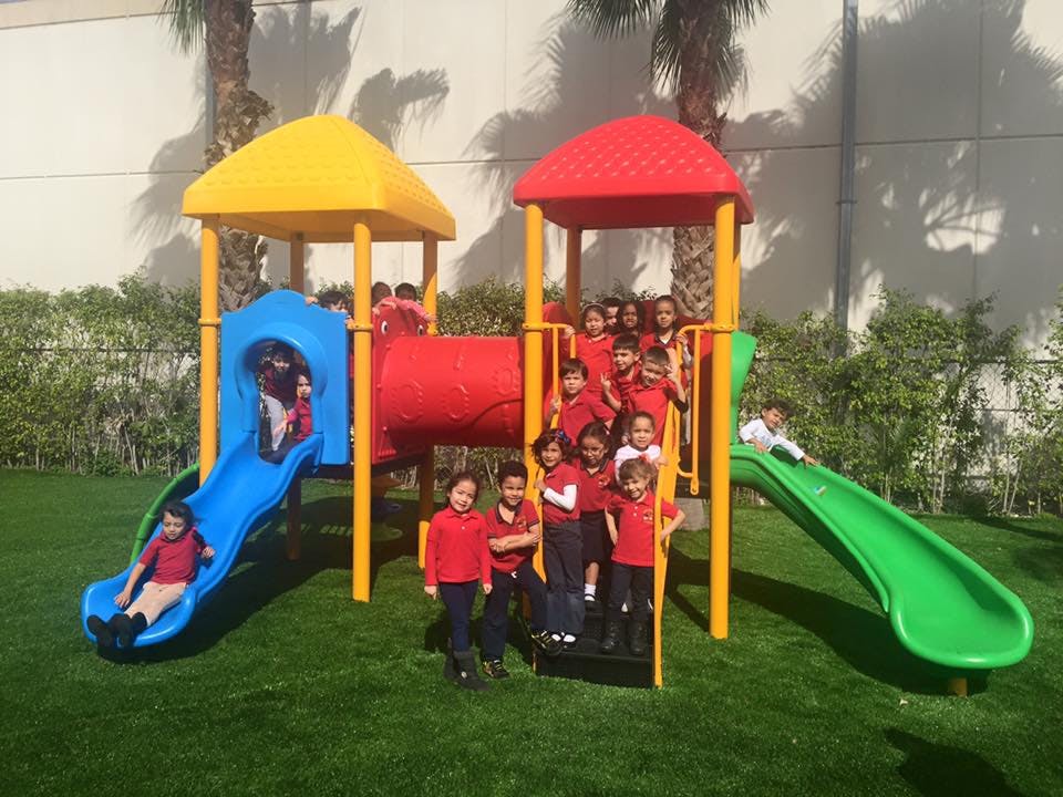Children playing on a colorful playground structure with slides