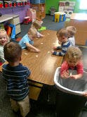 Children playing at a table in a classroom