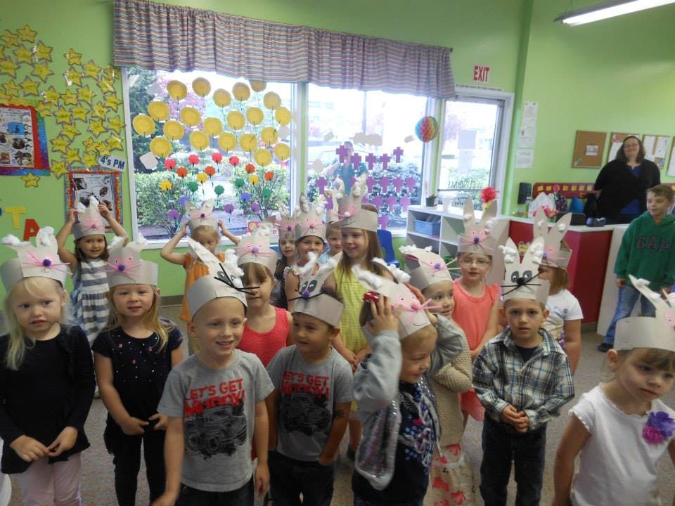 Group of children wearing paper crowns in a classroom