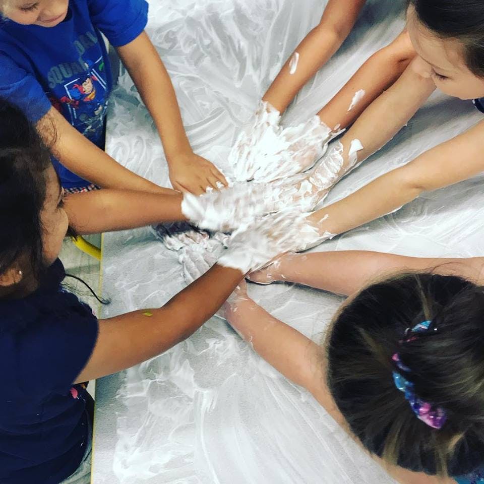 Children playing with shaving cream on a surface