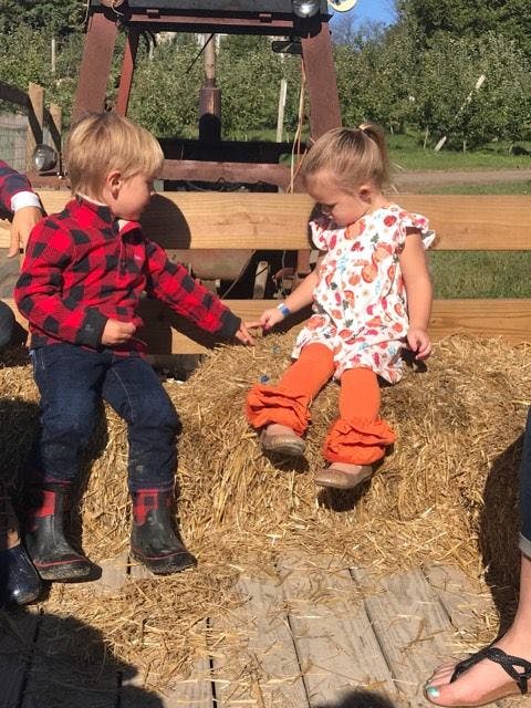 Two children sitting on hay bales
