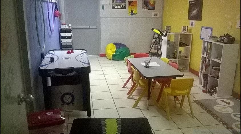 Air hockey table and small table with chairs in a room