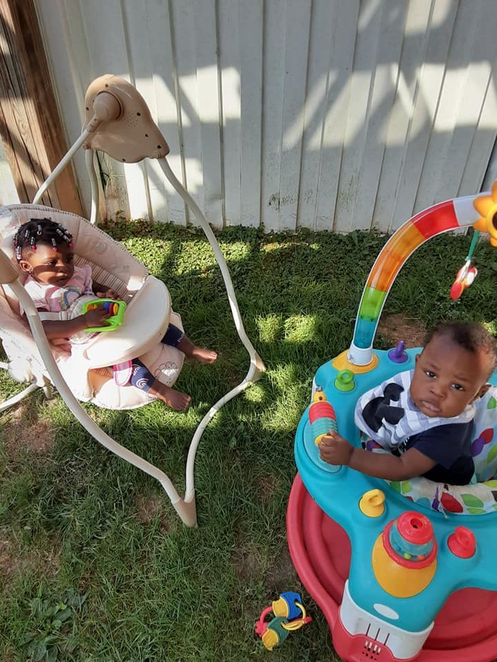 Two children in baby swings outdoors
