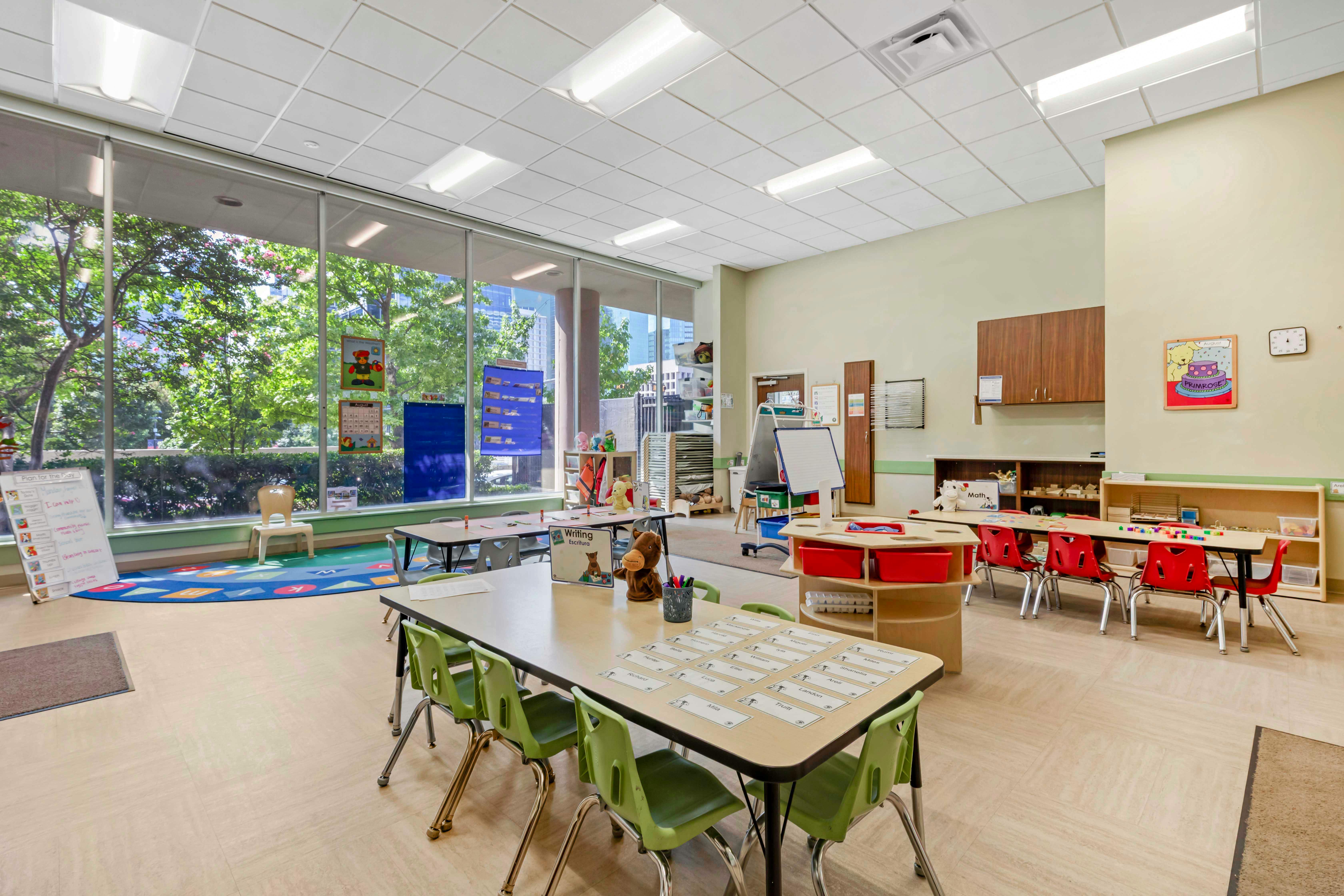 An empty early childhood classroom with multiple tables and chairs
