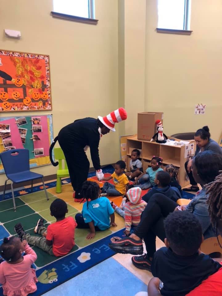 Person in Cat in the Hat costume interacting with children in a classroom