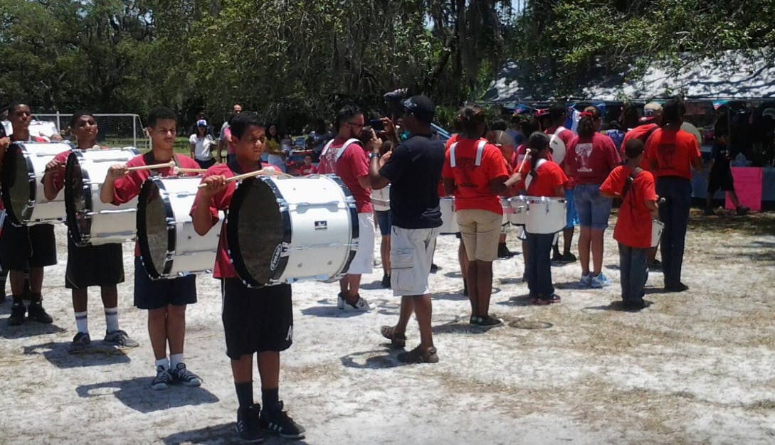 People in red shirts with drums outdoors