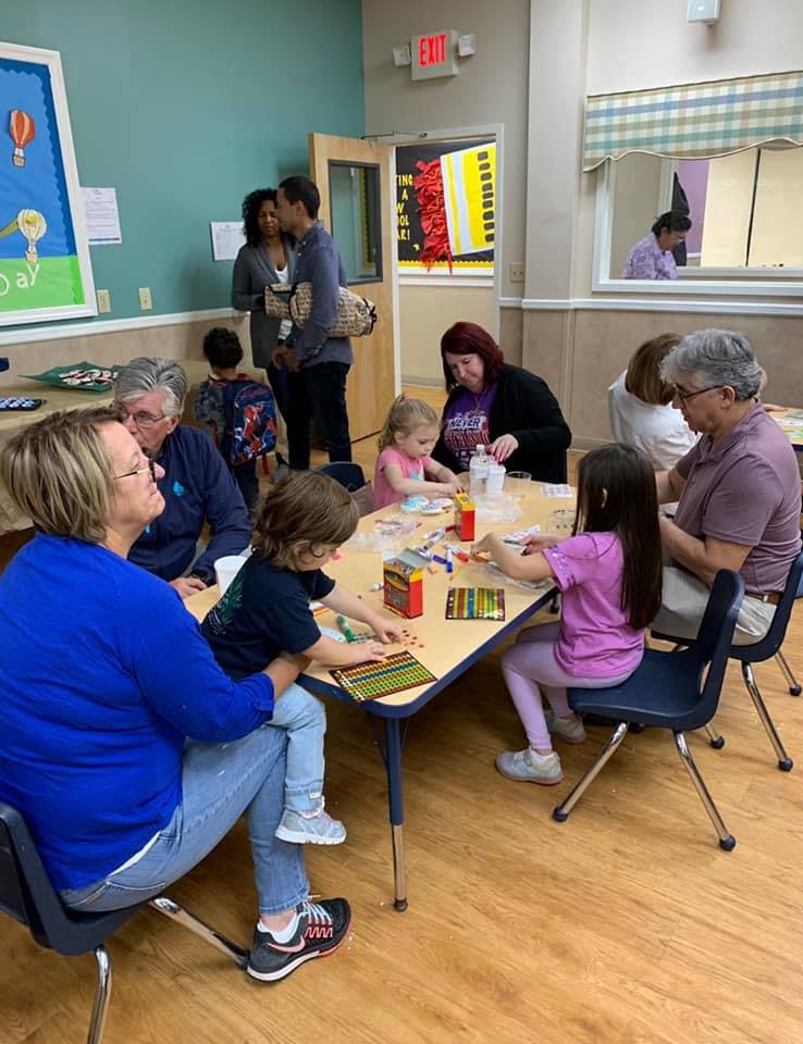 People and children gathered around tables in a room