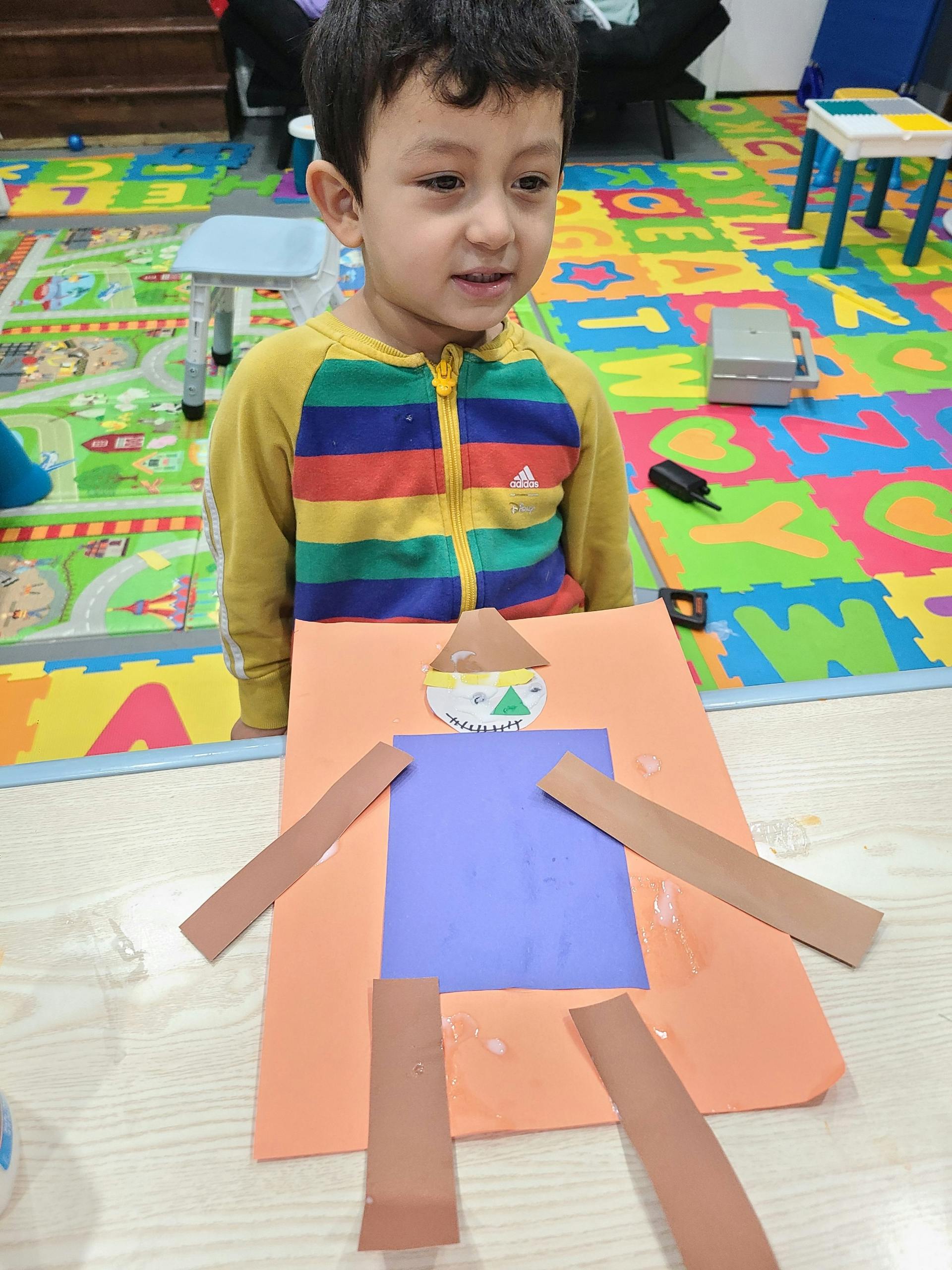 Child looking at a craft project made from paper cutouts
