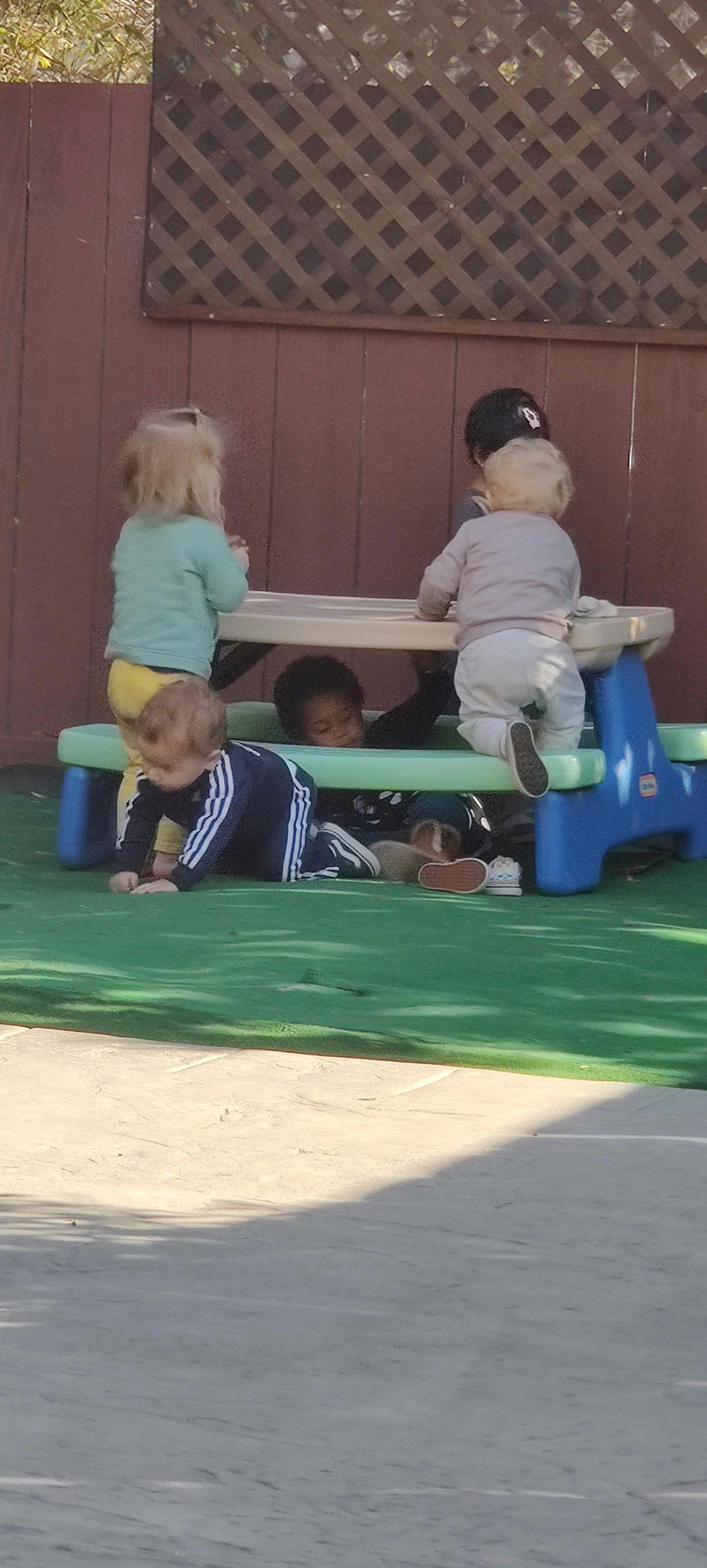 Children playing around a small picnic table