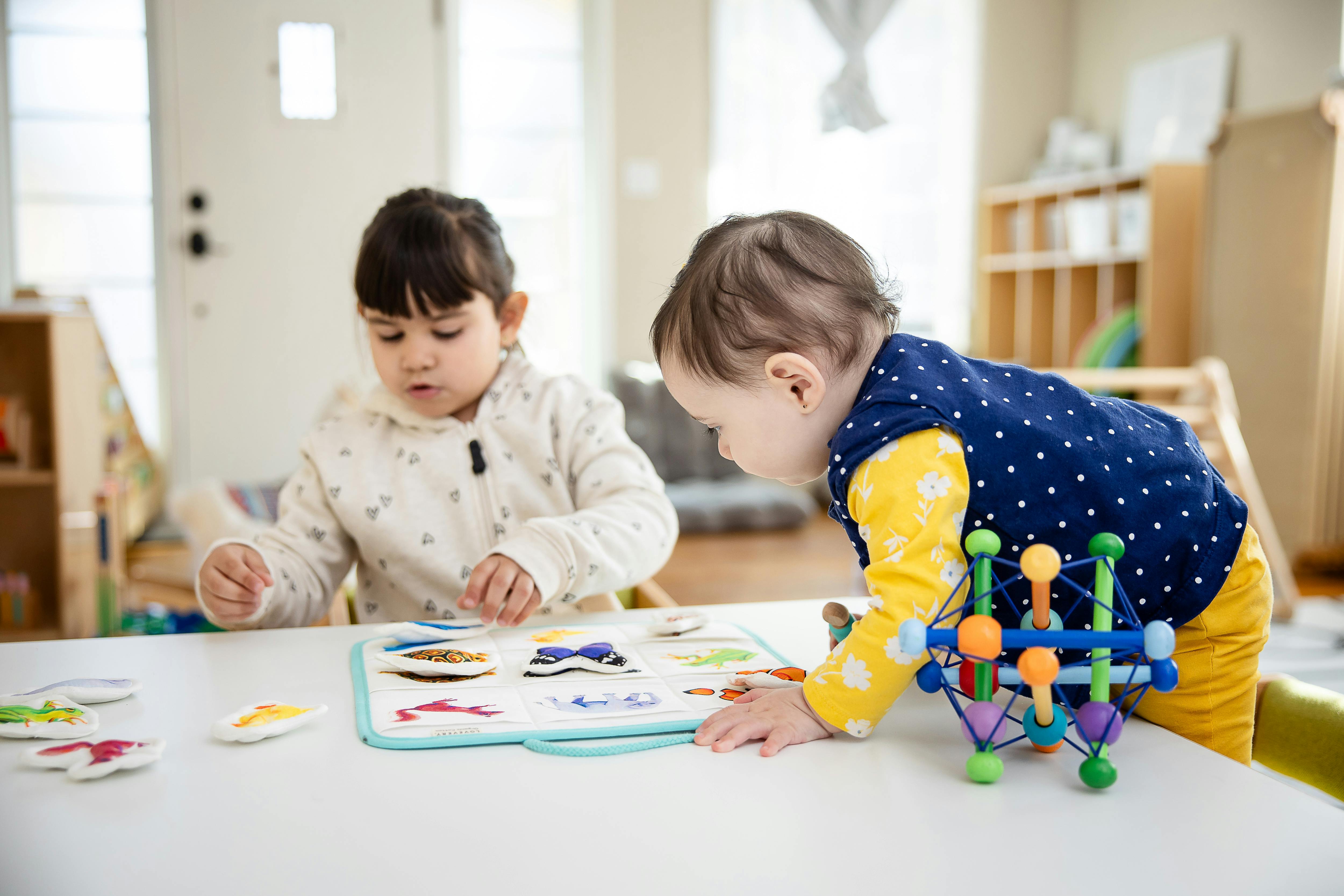 Two children playing with toys on a table