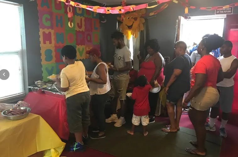 People gathered around a table with food at an event