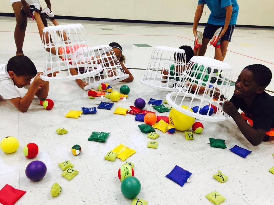 Children playing with baskets and colorful objects on the floor