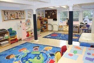 Playroom with colorful rugs and various toys