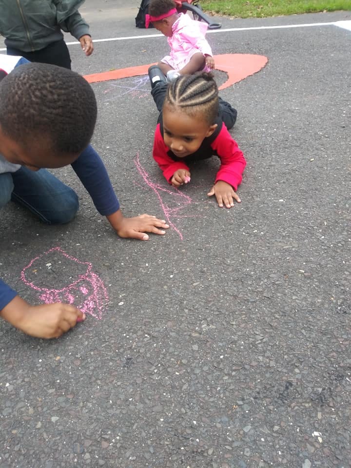 Children drawing with chalk on asphalt