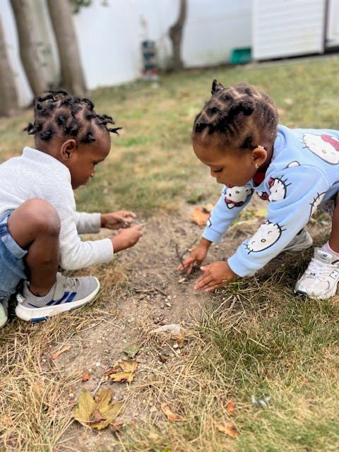 Two children playing in dirt outdoors in the dirt