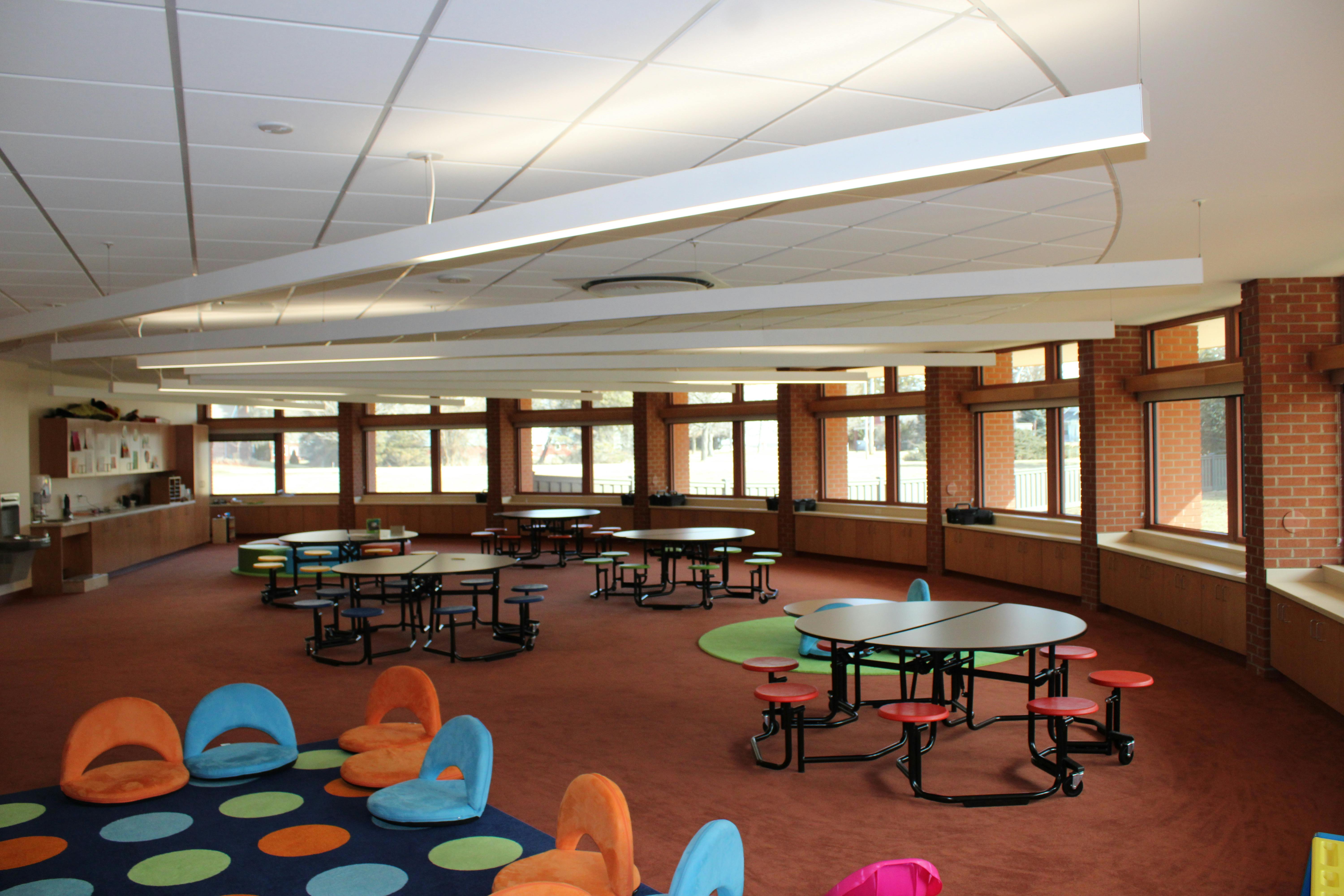Empty classroom with round tables and colorful chairs