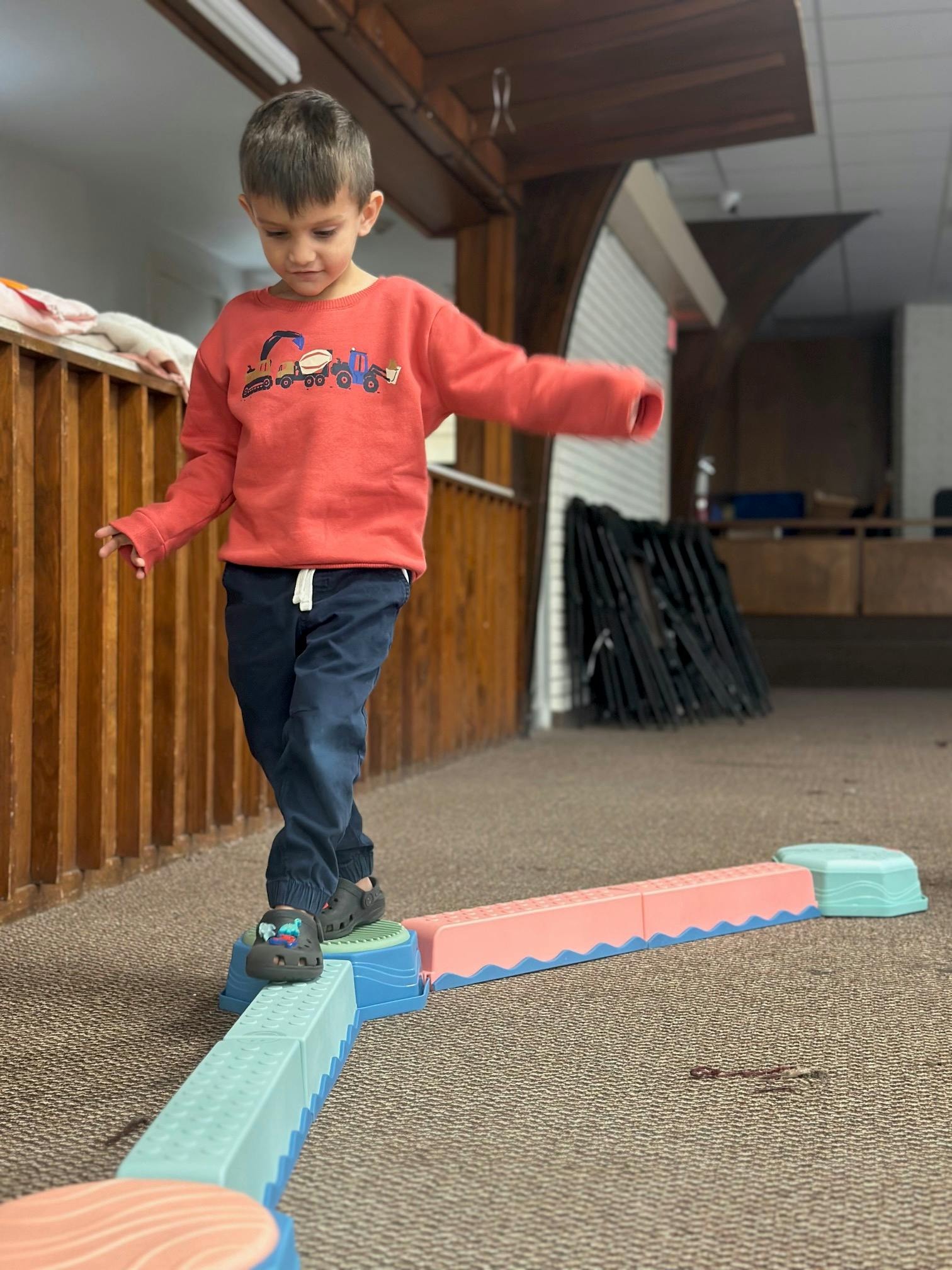 Child balancing on a colorful indoor obstacle course