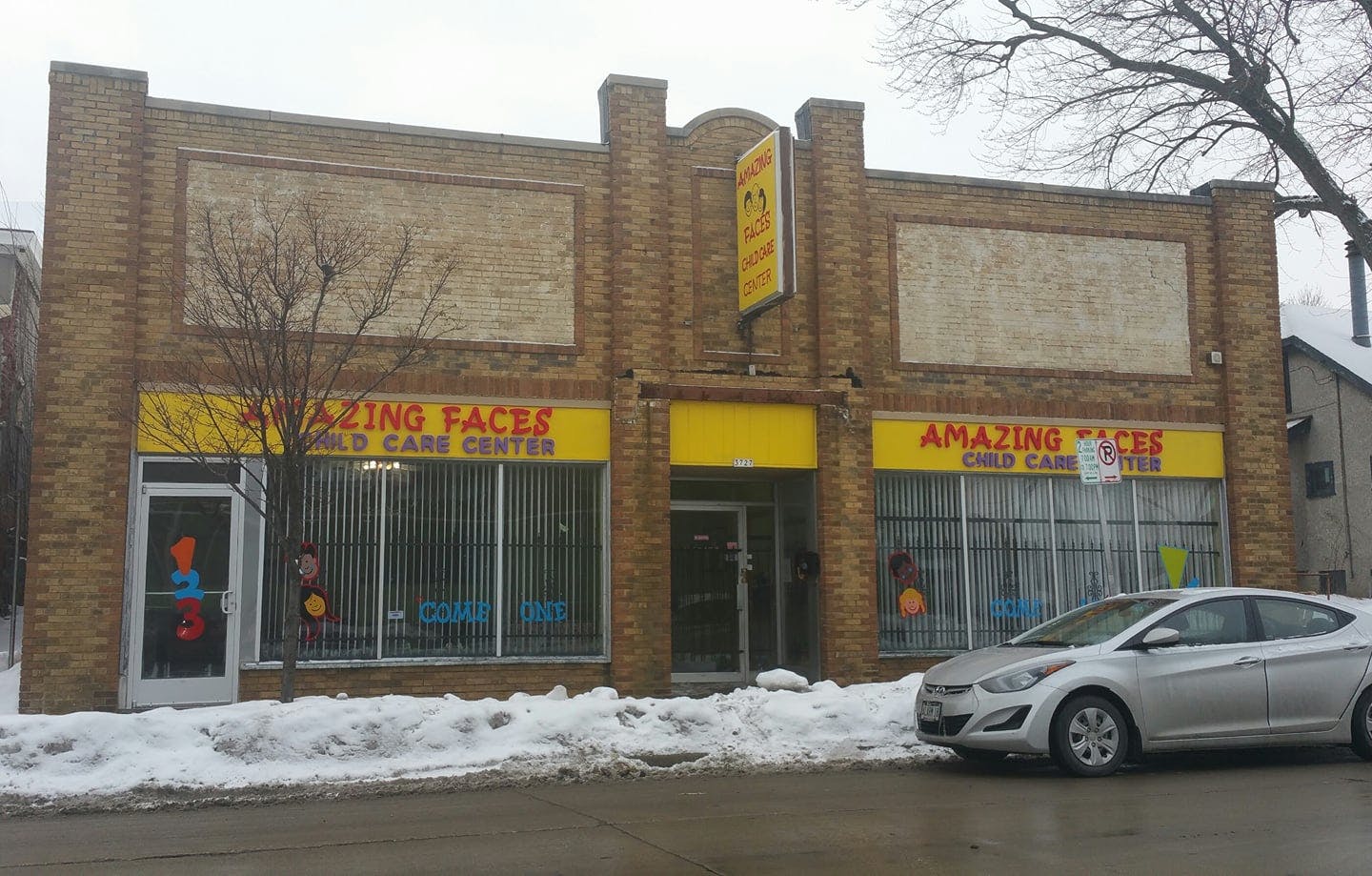 Brick building with Amazing Faces Child Care Center signs, snow on ground