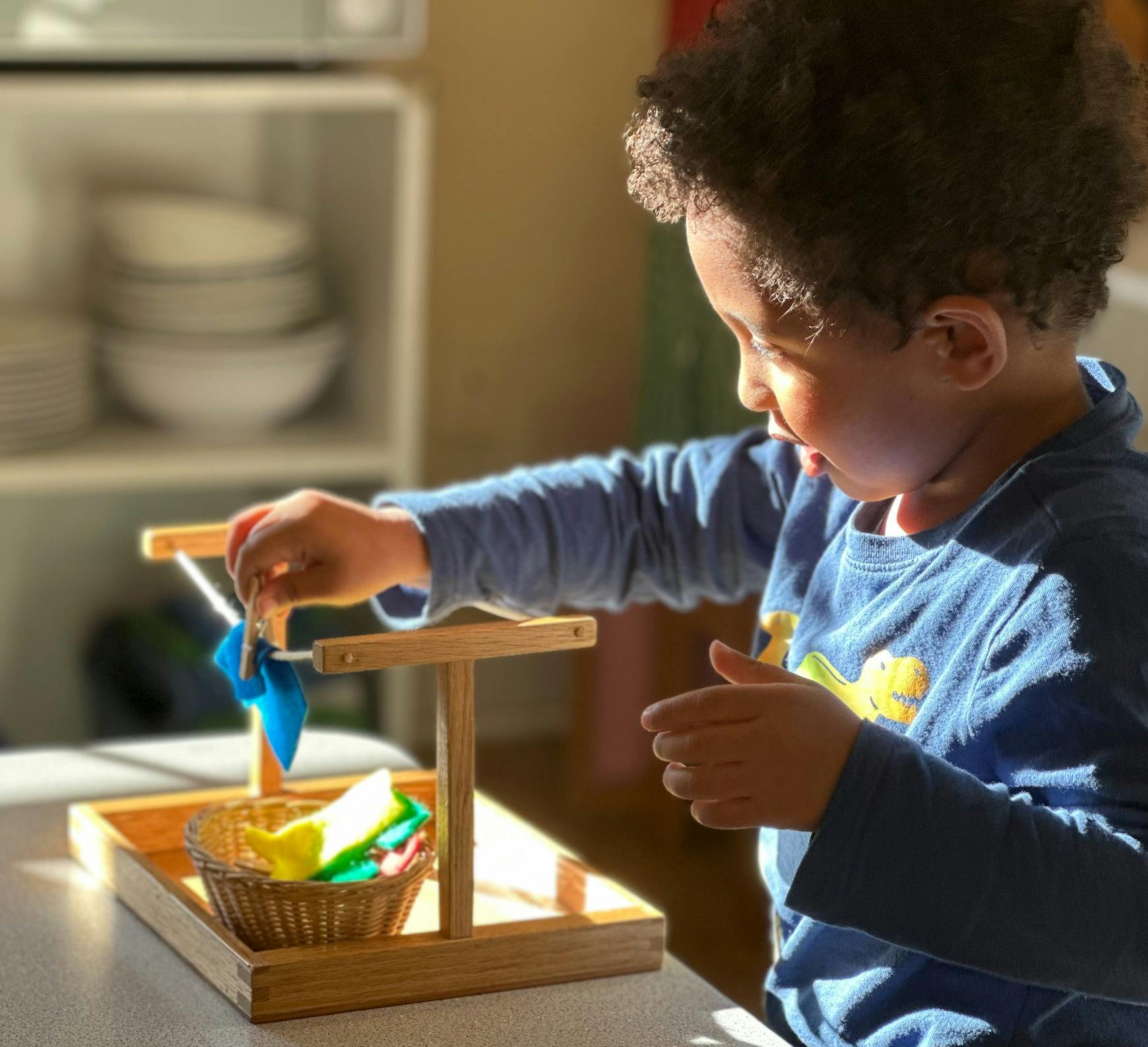 Child playing with a wooden toy and colorful fabric pieces