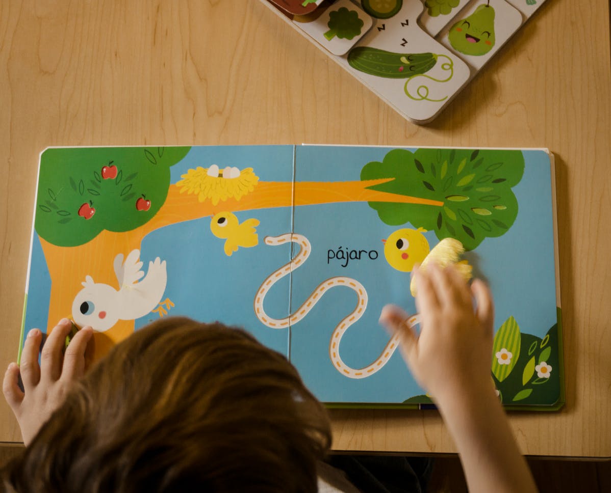 Child's hands interacting with a colorful children's book
