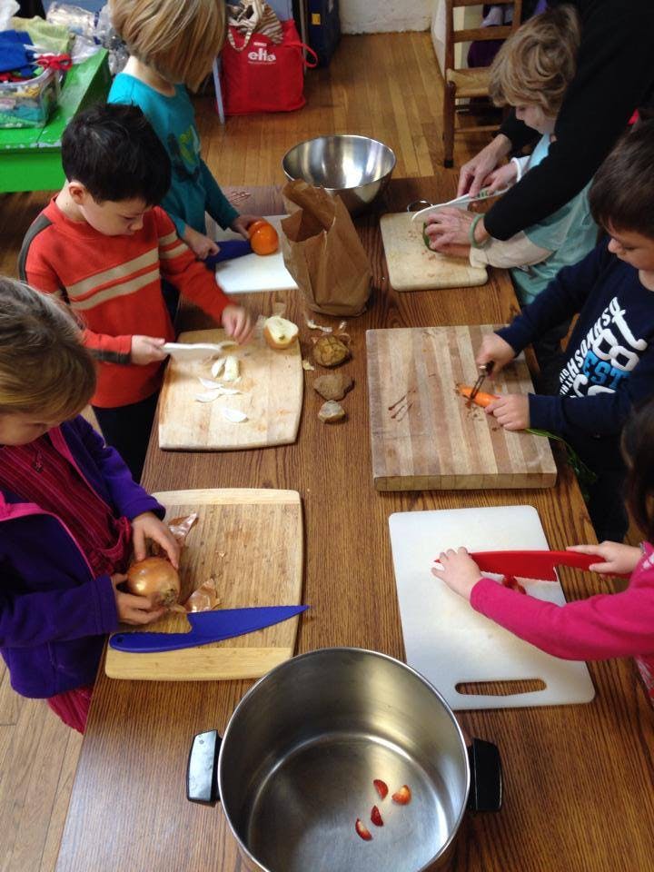 Children chopping vegetables on cutting boards