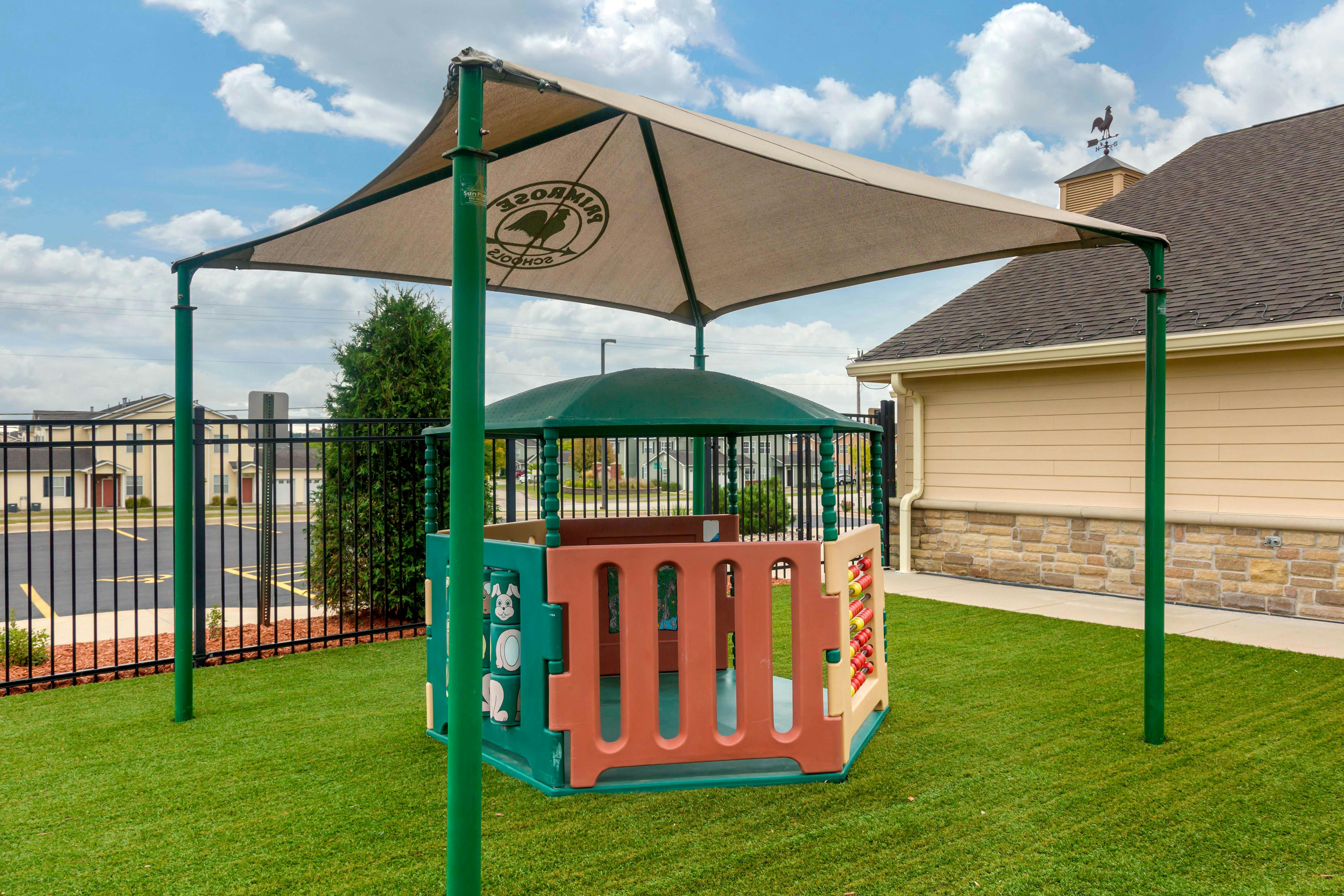 Playground area with a shade structure over a multi-colored play structure
