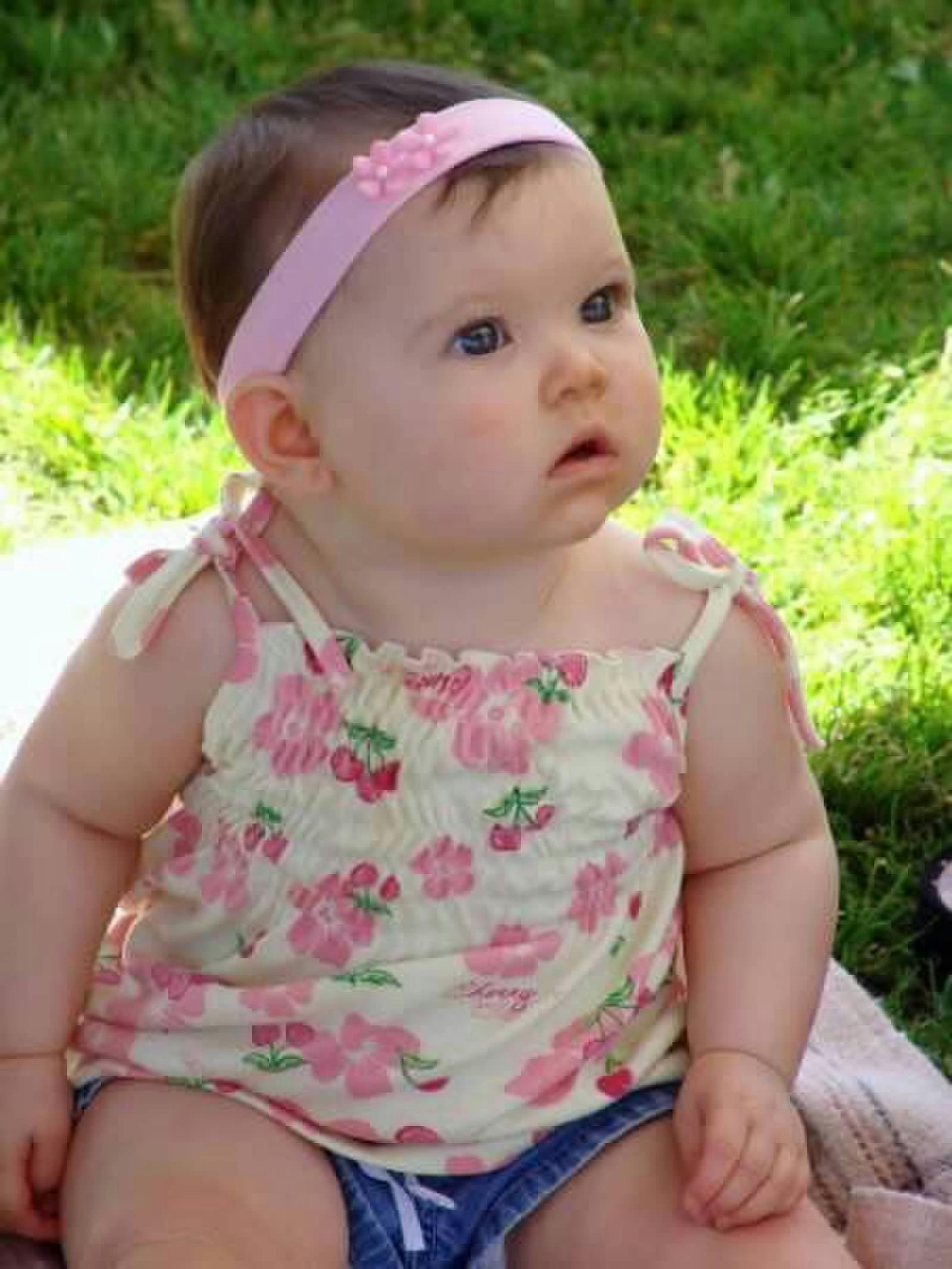 Child wearing a pink headband and floral top