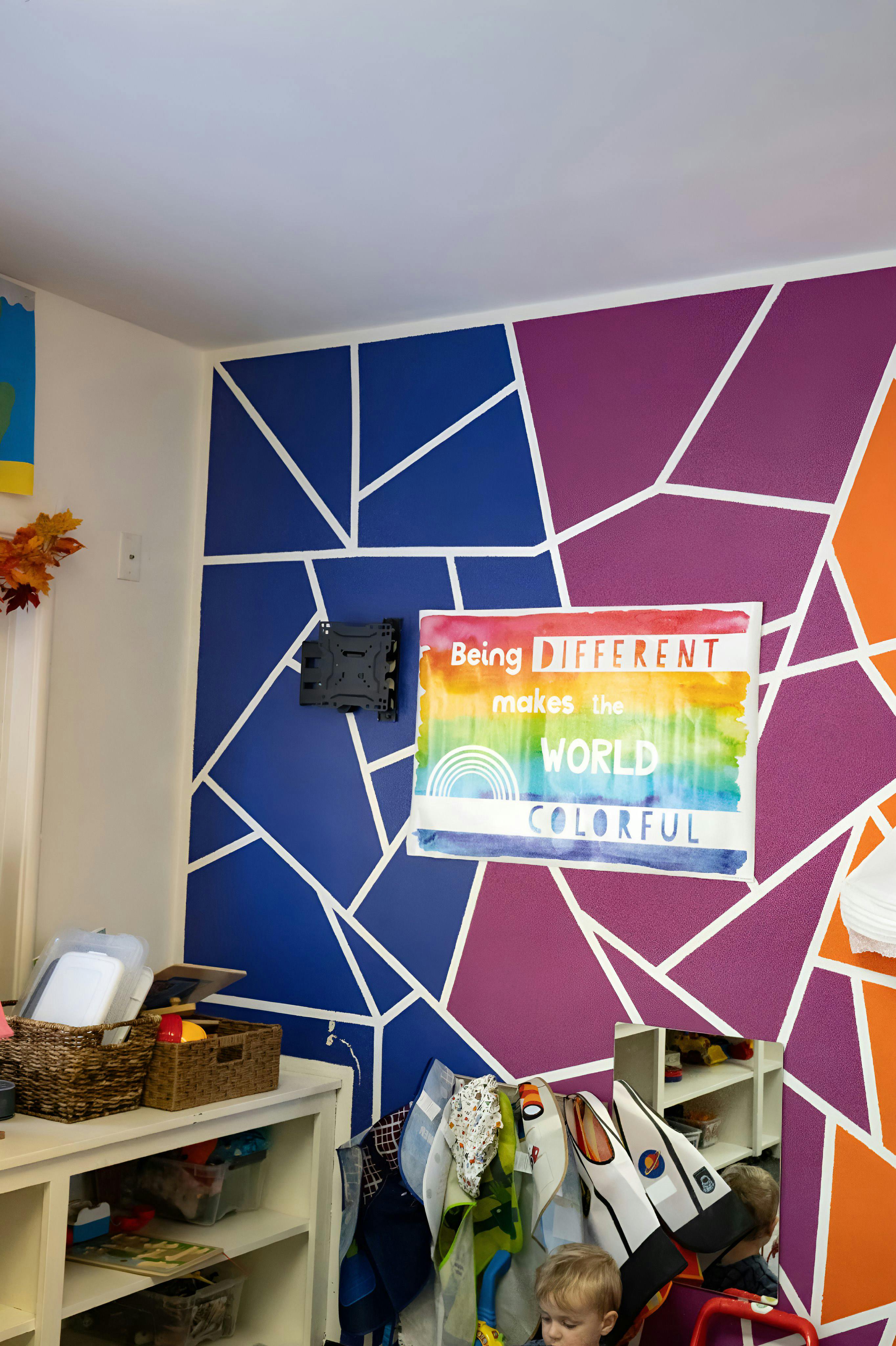 Classroom wall with geometric pattern and sign that says "Being different makes the world colorful"
