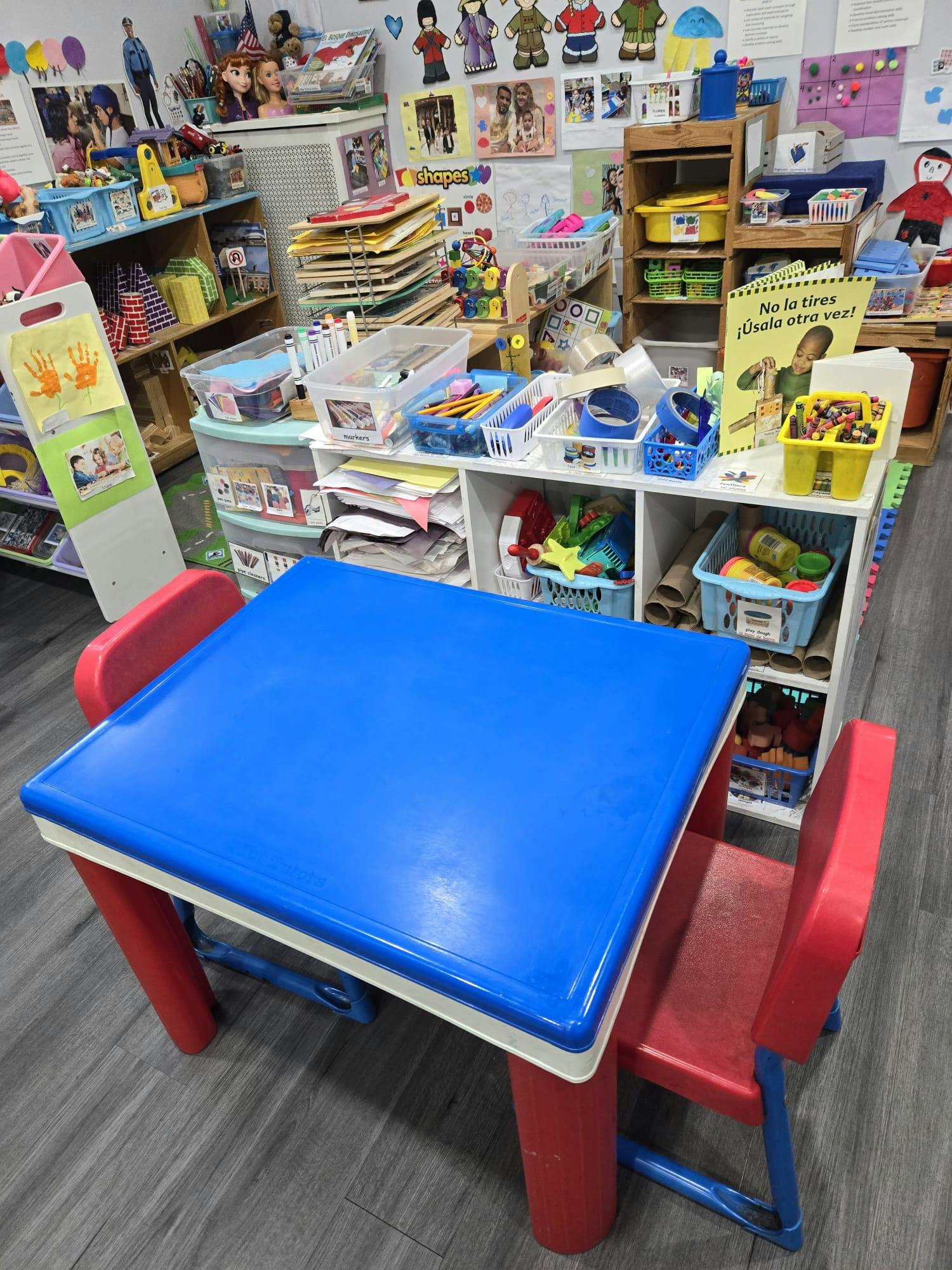 Blue and red children's table and chairs in a colorful classroom