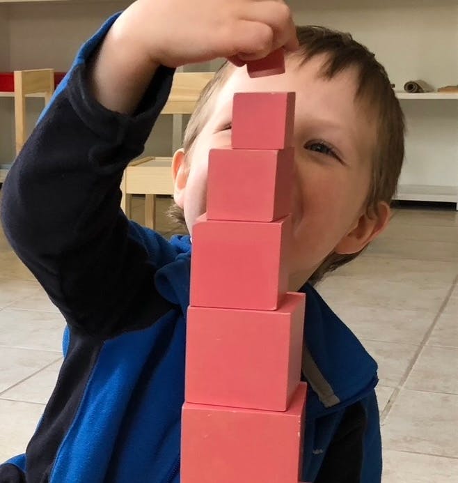 Child stacking a tower of wooden blocks