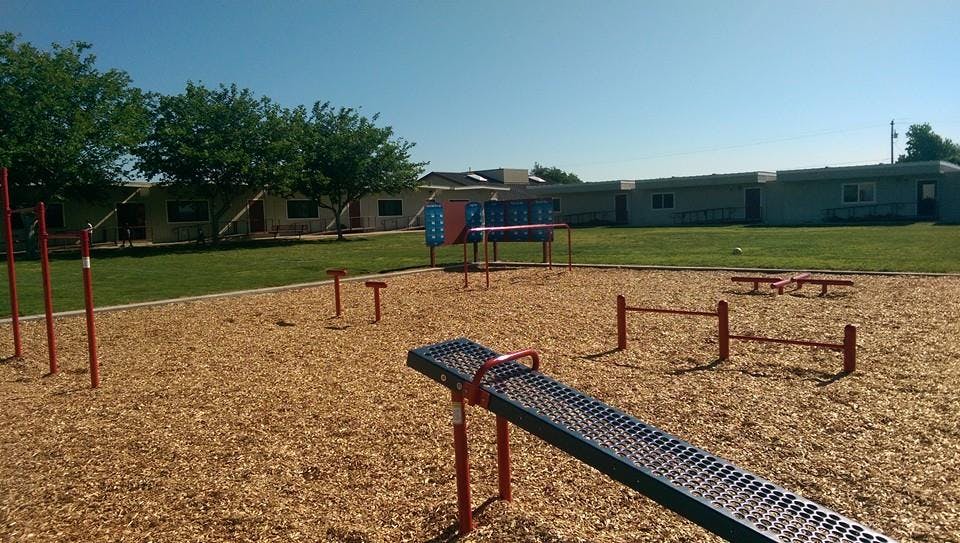 Outdoor playground with wood chips and various exercise equipment