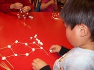 Child building a structure with toothpicks and marshmallows