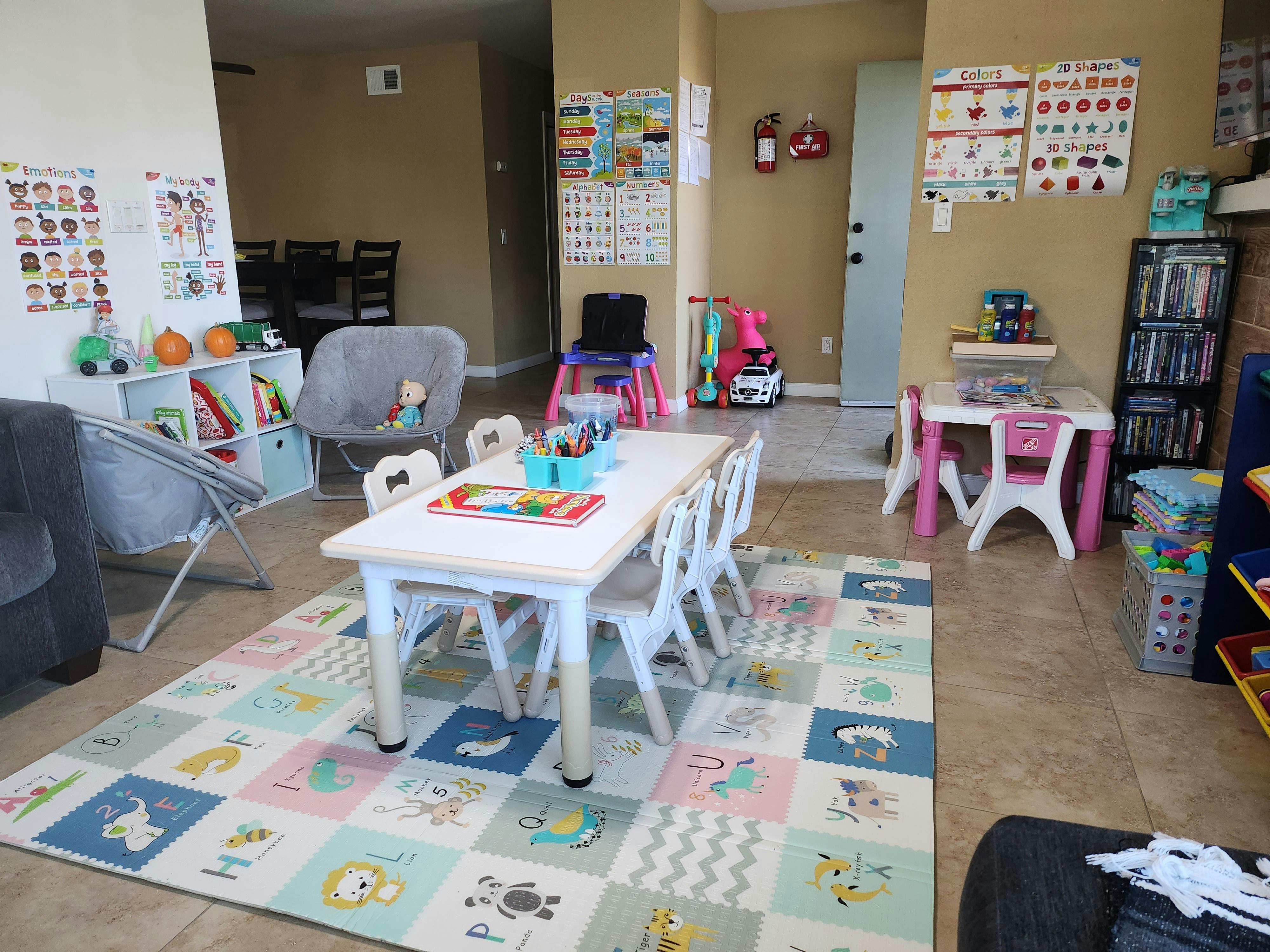 Playroom with small tables and chairs, colorful rug, and toys