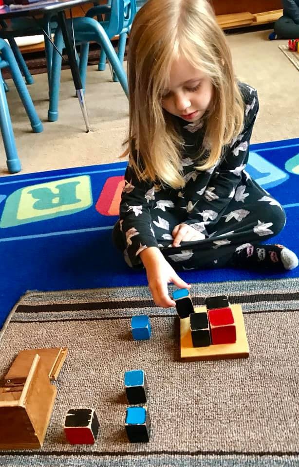 Child playing with colorful blocks on a rug