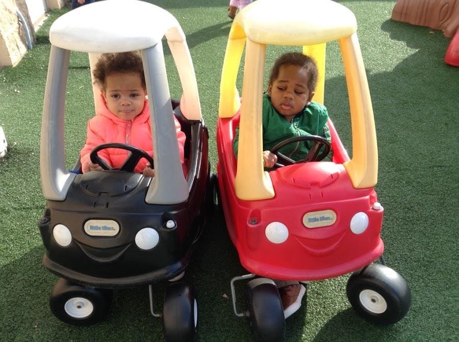 Two children in toy cars