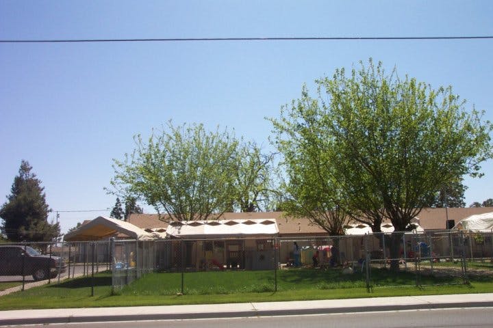 Building with a fence and trees in front