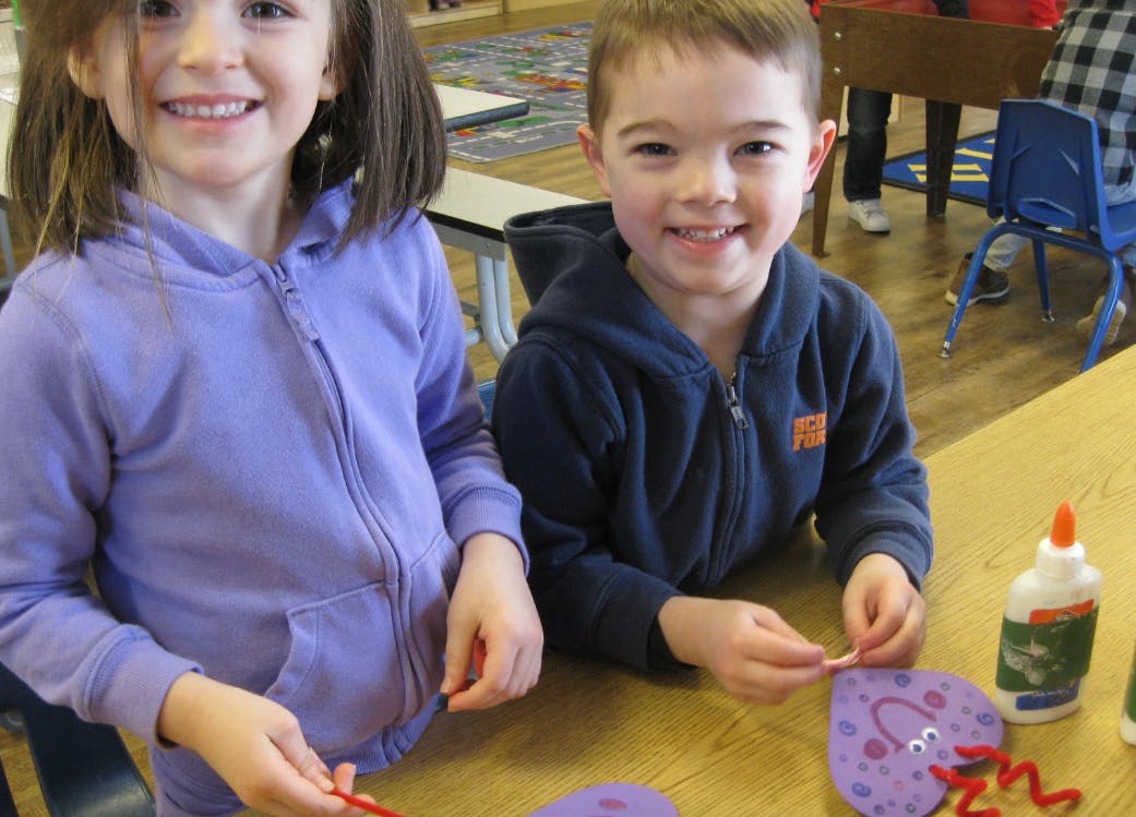 Two children crafting at a table