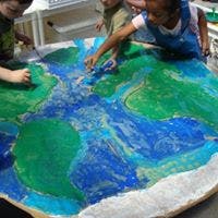 Children touching a large painted map of the world