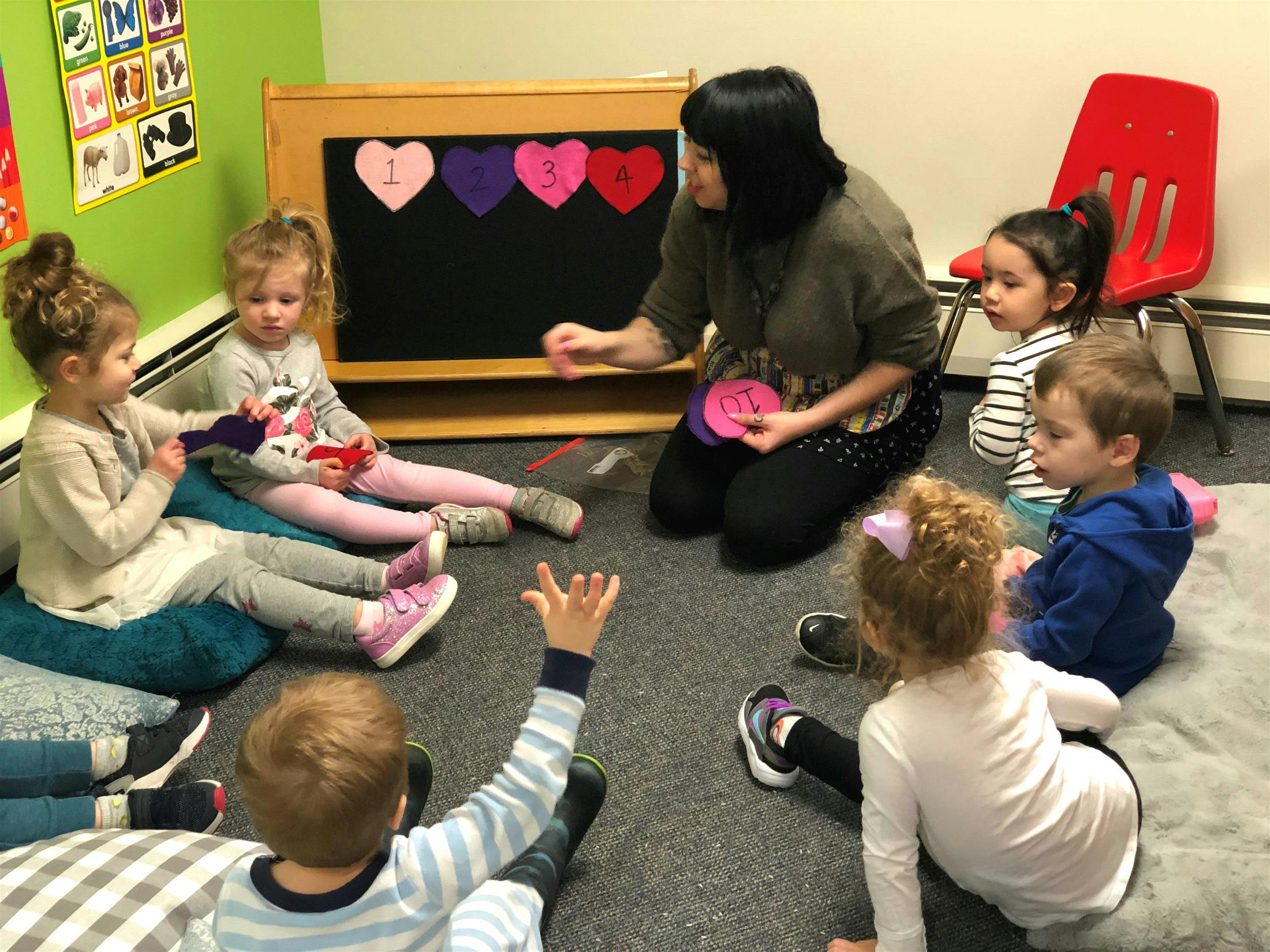 Adult and children sitting on floor in a classroom