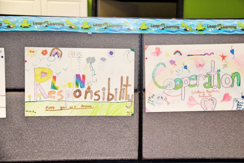Child's drawing with the word "Responsibility" and another with "Cooperation"